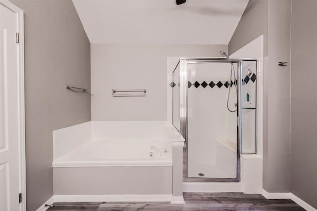 bathroom with hardwood / wood-style flooring, plus walk in shower, and lofted ceiling