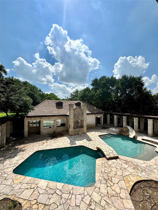 view of swimming pool featuring a patio and a water slide