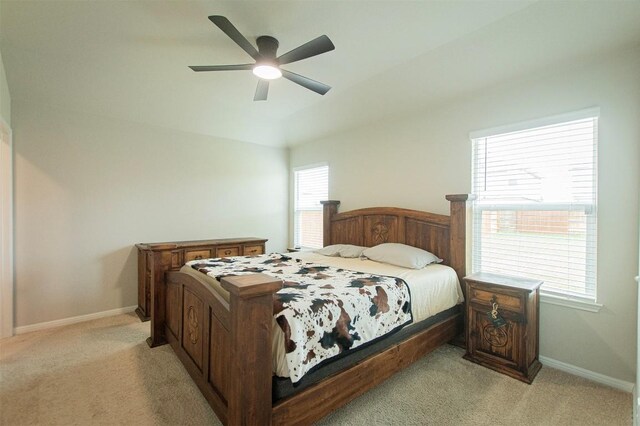 bedroom featuring multiple windows, light carpet, and ceiling fan