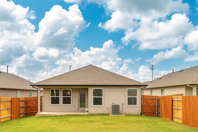 rear view of property with cooling unit, a yard, and a patio