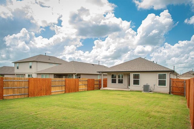 back of property with cooling unit and a lawn