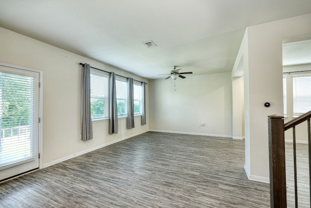 empty room featuring ceiling fan, wood-type flooring, and a healthy amount of sunlight