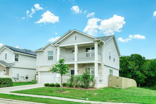 view of front of house with a balcony, a garage, solar panels, and a front yard