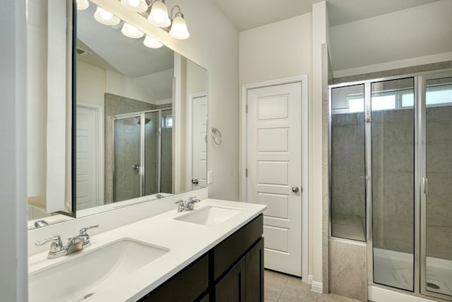 bathroom with double sink vanity, an enclosed shower, and tile patterned flooring