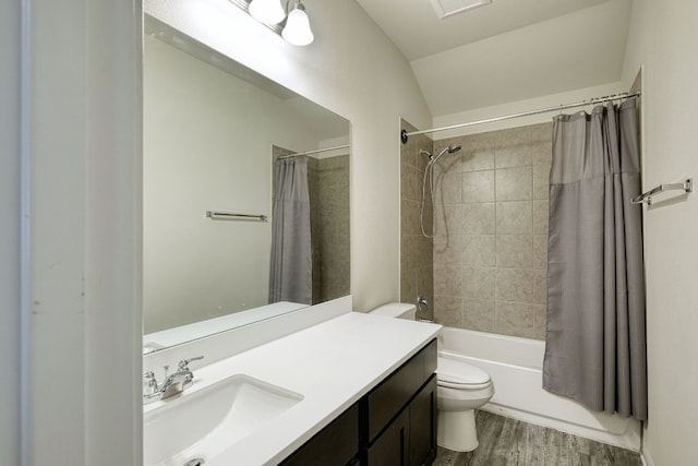 full bathroom featuring shower / bath combination with curtain, toilet, vanity, wood-type flooring, and vaulted ceiling