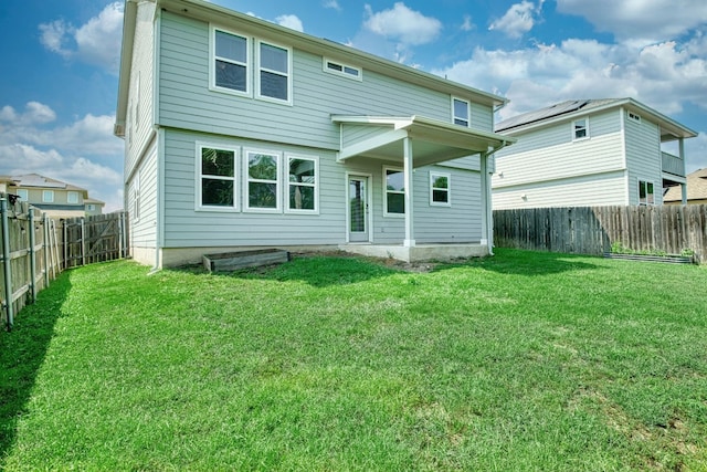 rear view of property with a lawn