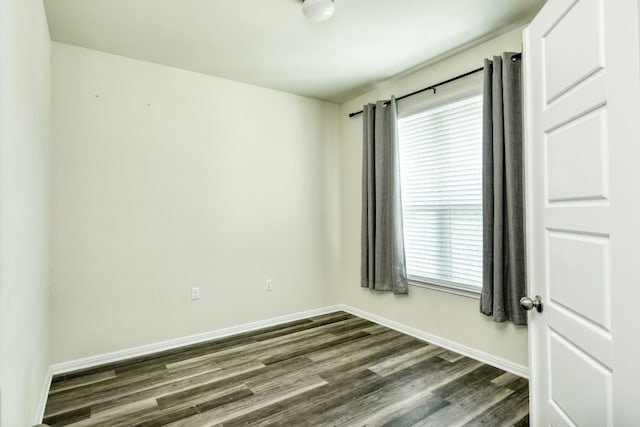 empty room with a wealth of natural light and hardwood / wood-style floors