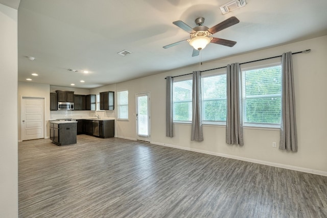 unfurnished living room featuring light wood-type flooring, ceiling fan, and plenty of natural light