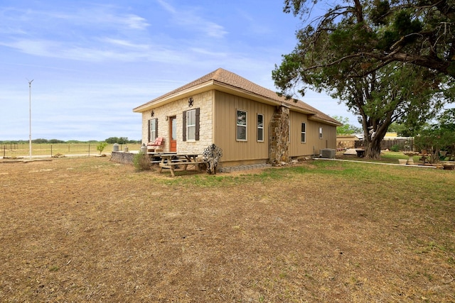 view of side of property with central air condition unit and a lawn