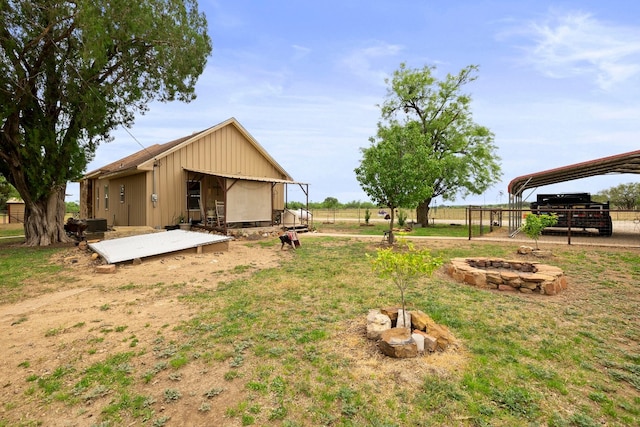 view of yard with a carport and an outdoor fire pit