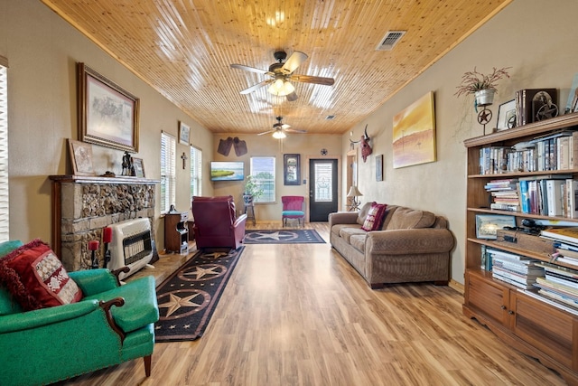 living room featuring light hardwood / wood-style floors, wooden ceiling, a fireplace, and ceiling fan