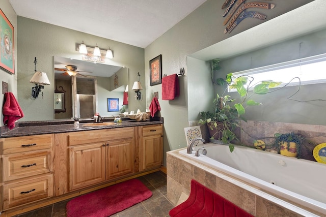 bathroom featuring a relaxing tiled tub, vanity, tile patterned flooring, and ceiling fan