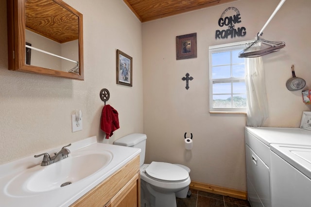 bathroom featuring tile patterned floors, washer and clothes dryer, toilet, and vanity