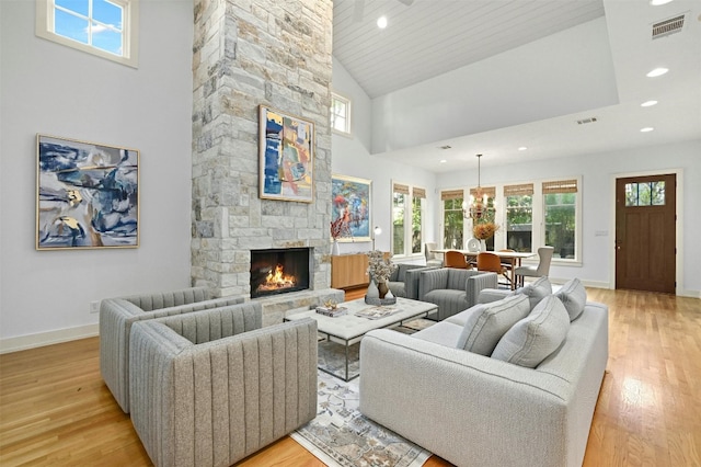 living room with a fireplace, light hardwood / wood-style flooring, and high vaulted ceiling