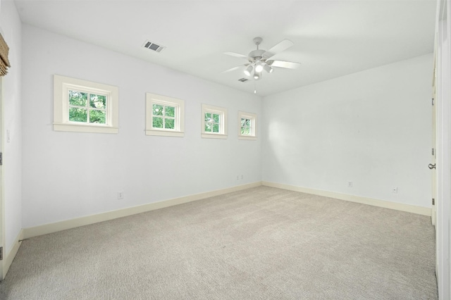 carpeted spare room featuring ceiling fan and a healthy amount of sunlight