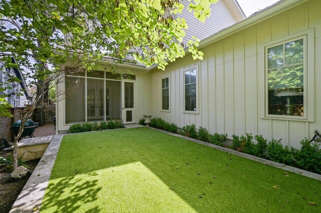 rear view of property featuring a sunroom and a yard