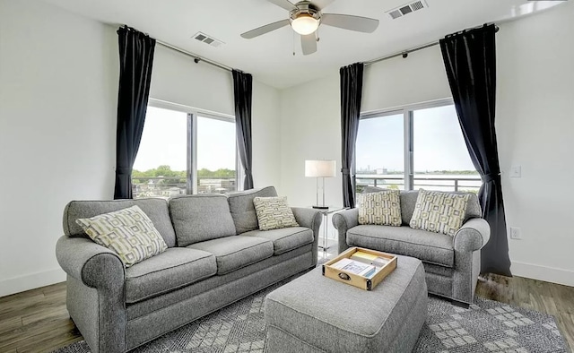 living room with plenty of natural light, ceiling fan, and dark hardwood / wood-style flooring