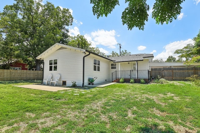 rear view of house featuring a patio area and a lawn