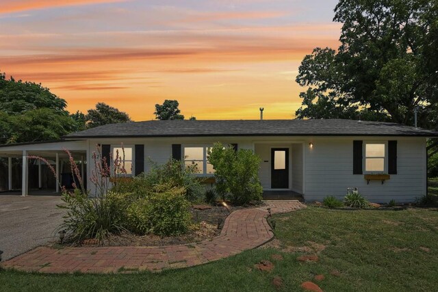 view of front of home with a yard and a carport