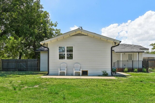 rear view of house with a lawn and a patio area