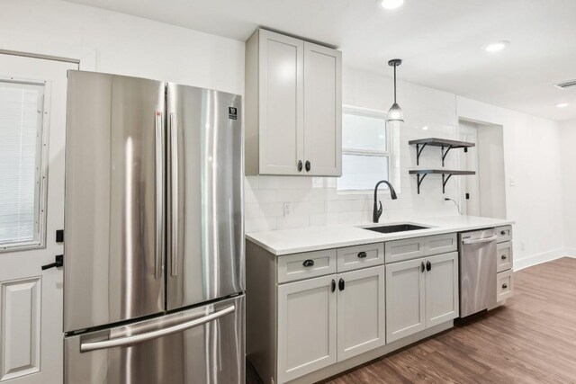 kitchen featuring gray cabinets, stainless steel appliances, decorative backsplash, sink, and dark hardwood / wood-style floors