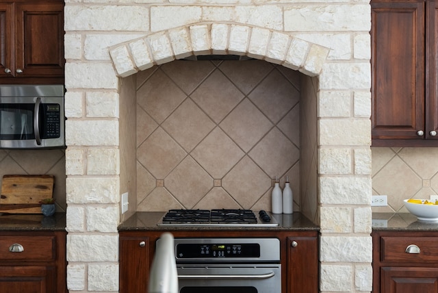 kitchen with dark stone countertops, decorative backsplash, and stainless steel appliances