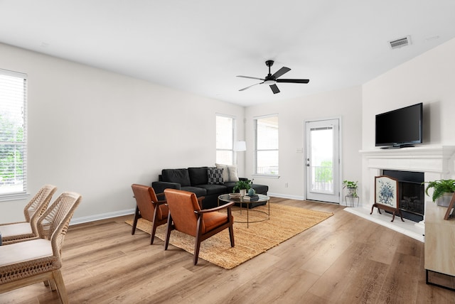 living room with ceiling fan and light hardwood / wood-style flooring