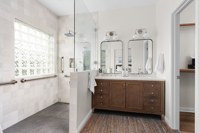 bathroom featuring tiled shower and vanity