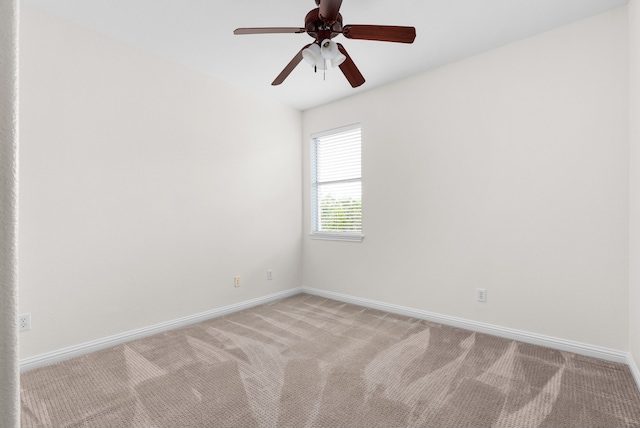 spare room featuring light colored carpet and ceiling fan