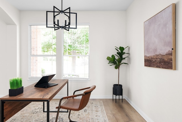 home office featuring a chandelier and light hardwood / wood-style flooring