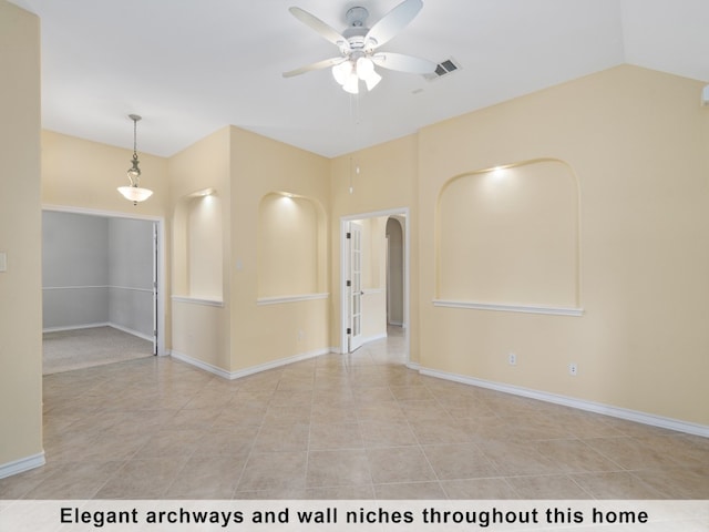 empty room with light tile patterned flooring, ceiling fan, and vaulted ceiling