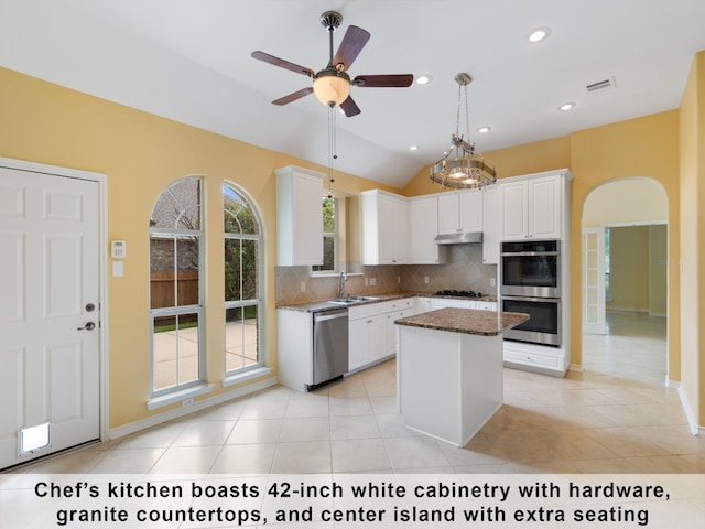 kitchen featuring white cabinetry, decorative light fixtures, light tile patterned flooring, appliances with stainless steel finishes, and backsplash