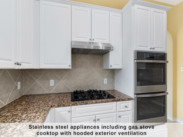 kitchen with white cabinetry, stainless steel double oven, and backsplash