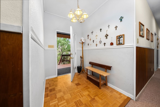 foyer entrance featuring a chandelier, light parquet flooring, and ornamental molding