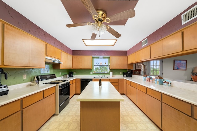 kitchen featuring dishwasher, a kitchen island, sink, ceiling fan, and gas range oven