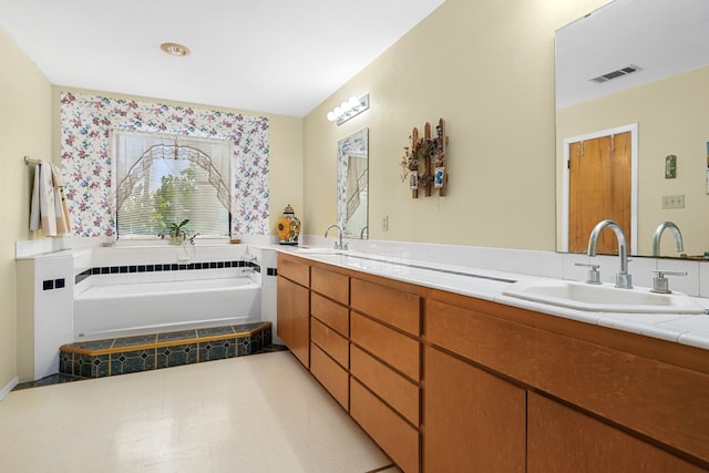 bathroom featuring tiled bath and vanity