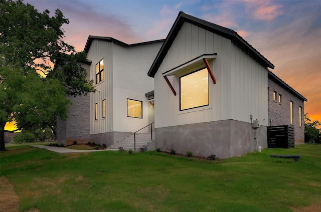 property exterior at dusk with a yard and central AC unit