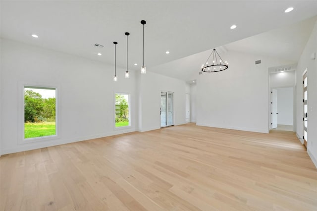 unfurnished living room featuring light hardwood / wood-style floors, a healthy amount of sunlight, and high vaulted ceiling