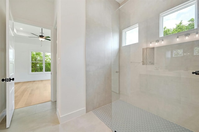 bathroom with plenty of natural light, hardwood / wood-style flooring, tiled shower, and ceiling fan