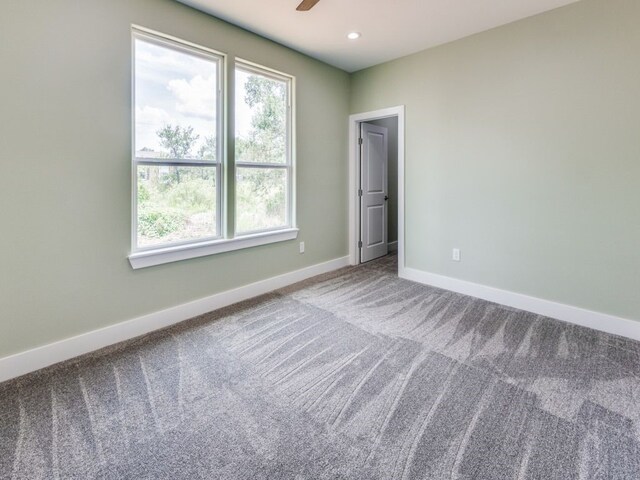 unfurnished room with carpet flooring and ceiling fan