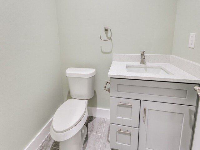 bathroom with vanity, wood-type flooring, and toilet