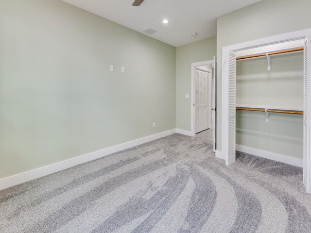 unfurnished bedroom featuring ceiling fan, a closet, and light colored carpet