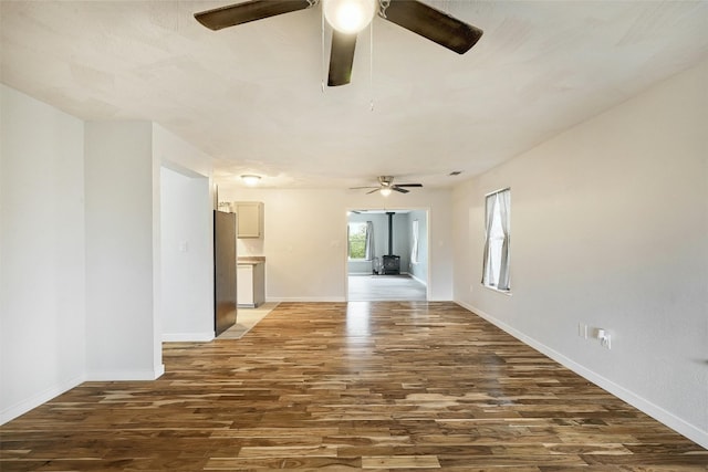 unfurnished living room with dark hardwood / wood-style floors and ceiling fan