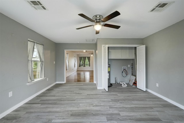 unfurnished living room featuring ceiling fan and light wood-type flooring