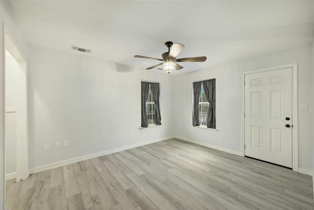 empty room with ceiling fan and light hardwood / wood-style flooring