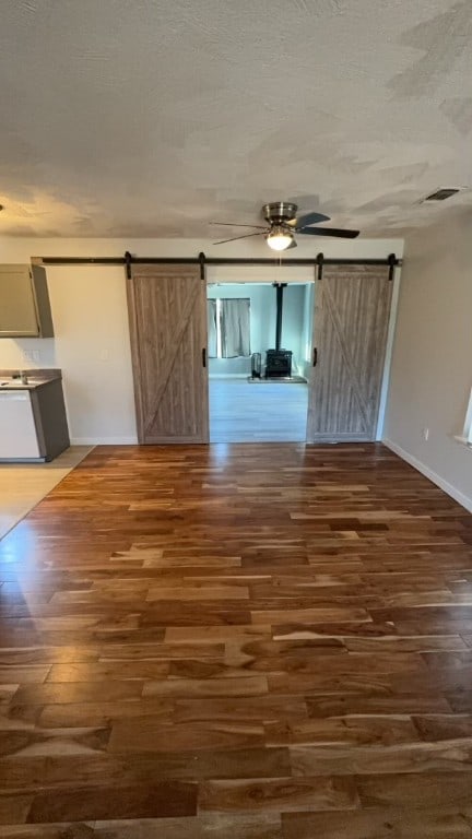 unfurnished room featuring dark wood-type flooring and a barn door