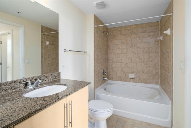 full bathroom featuring vanity, tiled shower / bath combo, tile patterned floors, and toilet