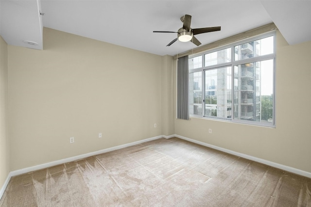 empty room with light colored carpet and ceiling fan