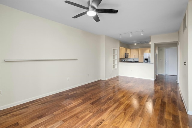 unfurnished living room with wood-type flooring, track lighting, ceiling fan, and built in shelves