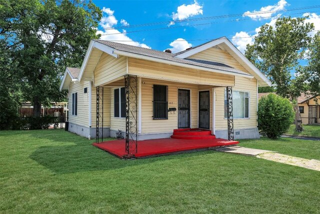 bungalow with covered porch and a front yard